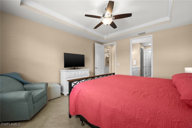 bedroom with a raised ceiling, ceiling fan, crown molding, and ensuite bathroom