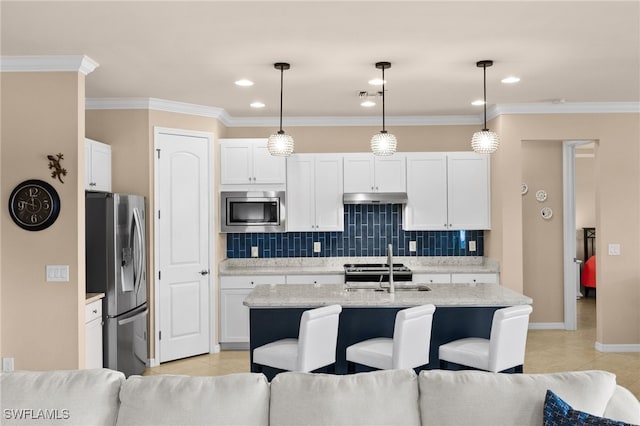 kitchen with white cabinets, hanging light fixtures, appliances with stainless steel finishes, and tasteful backsplash