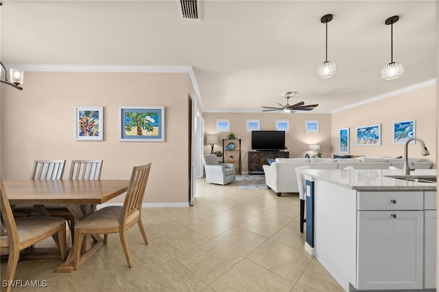 dining room featuring ceiling fan, crown molding, and sink