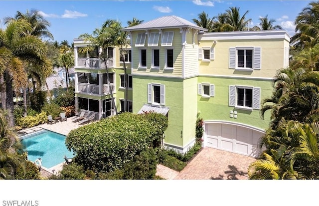 370 11th Ave S Unit 2, Naples, FL 34102 - view of property with decorative driveway, a garage, and an outdoor pool