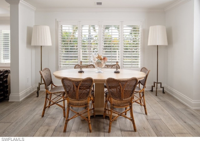 dining space featuring crown molding and light wood-type flooring