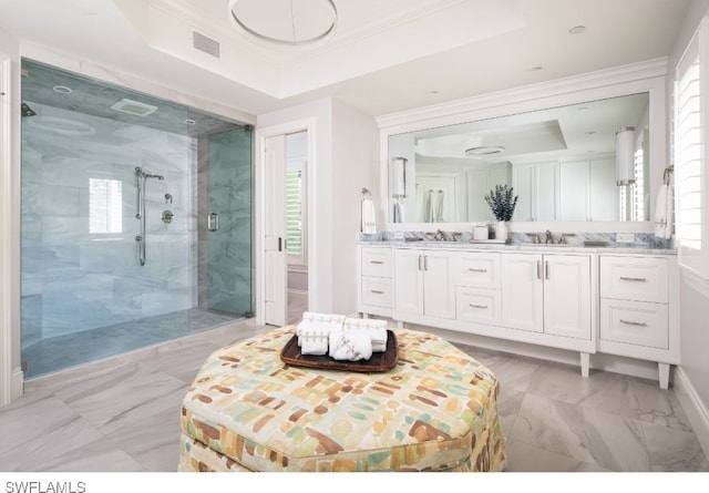 bathroom featuring vanity, a raised ceiling, ornamental molding, and a shower with shower door