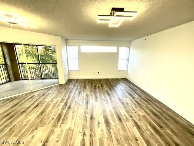 spare room with a textured ceiling and hardwood / wood-style flooring