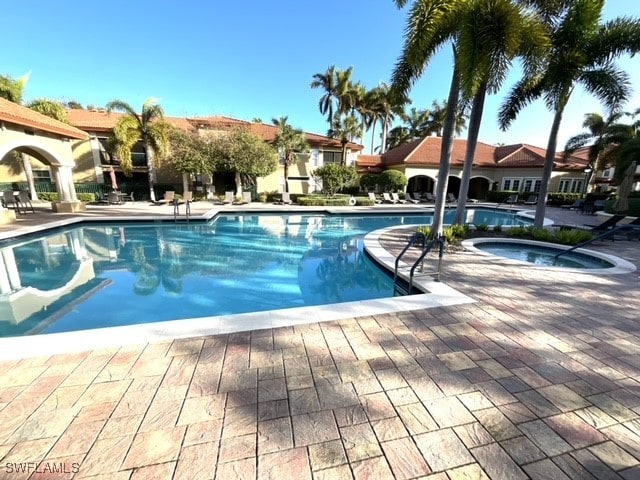 view of swimming pool with a community hot tub and a patio