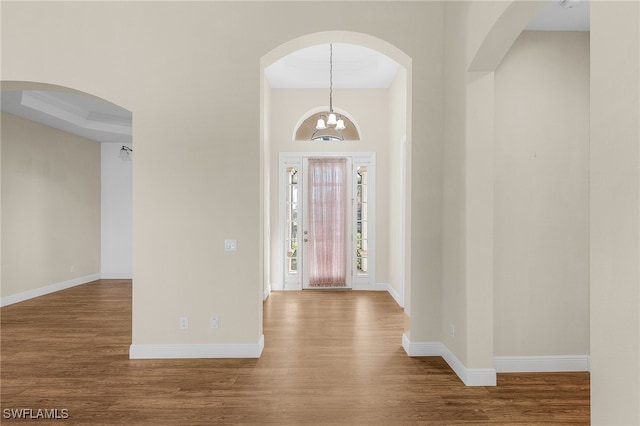 entrance foyer with wood-type flooring and an inviting chandelier