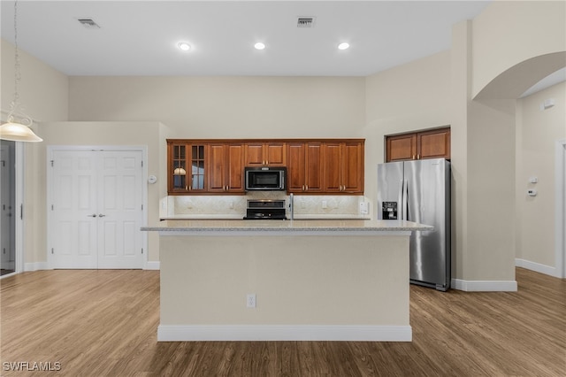 kitchen featuring black appliances, light wood-type flooring, and a kitchen island