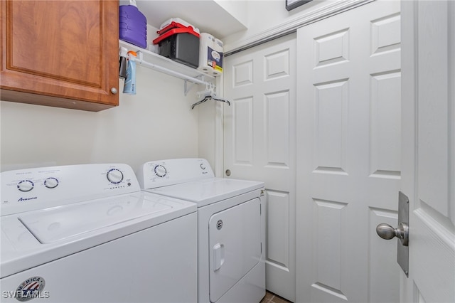 laundry room featuring separate washer and dryer and cabinets