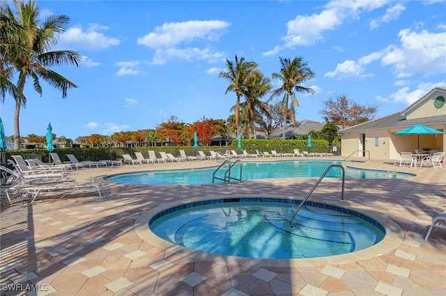 view of swimming pool with a patio area and a hot tub