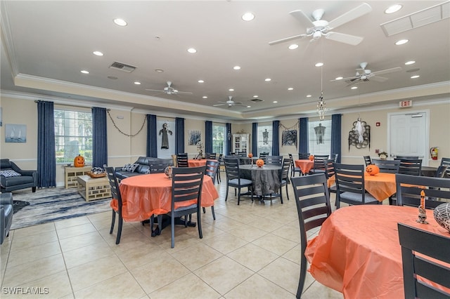 tiled dining area featuring ornamental molding, a raised ceiling, and ceiling fan