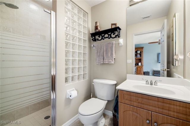 bathroom featuring vanity, ceiling fan, toilet, and a shower with door