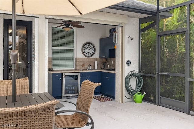 sunroom / solarium with wine cooler, sink, and ceiling fan