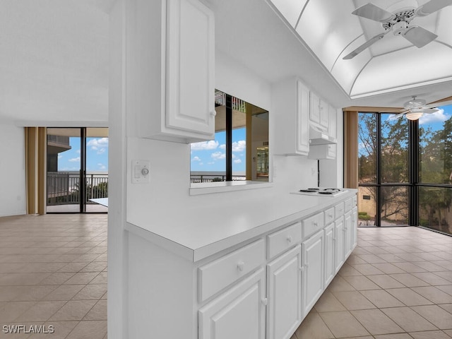 kitchen featuring white stovetop, white cabinetry, ceiling fan, and light tile patterned floors