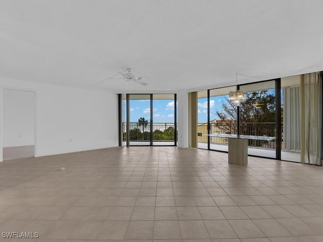 tiled spare room featuring floor to ceiling windows and ceiling fan