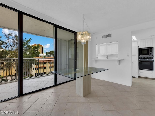 unfurnished dining area with expansive windows, an inviting chandelier, and light tile patterned floors