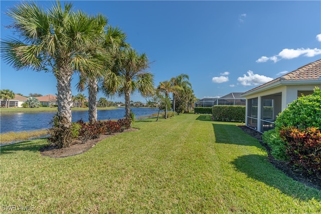 view of yard with a water view and a lanai