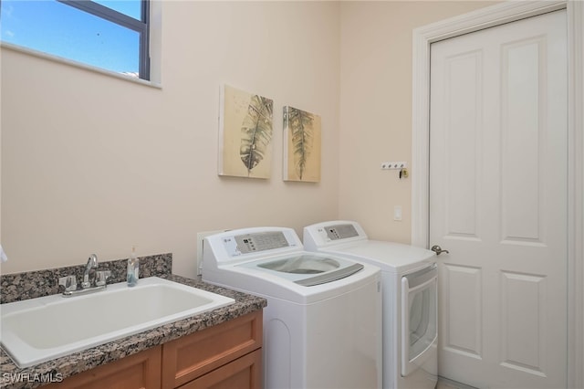 clothes washing area featuring sink and washer and dryer