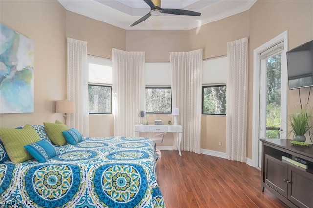 bedroom with crown molding, multiple windows, wood-type flooring, and ceiling fan