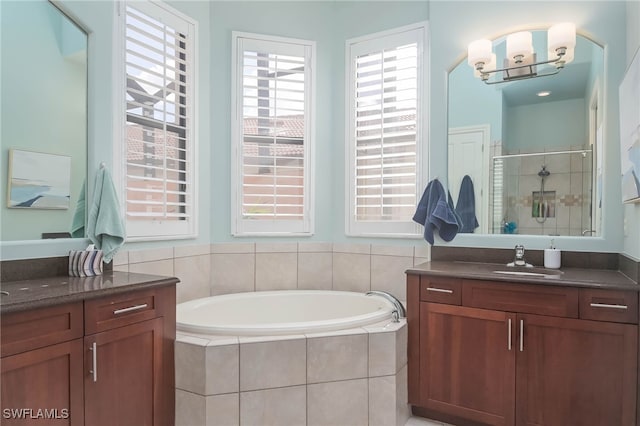 bathroom featuring vanity, a healthy amount of sunlight, and separate shower and tub