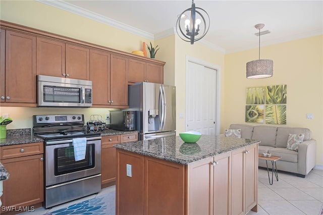 kitchen featuring a kitchen island, dark stone counters, ornamental molding, pendant lighting, and appliances with stainless steel finishes