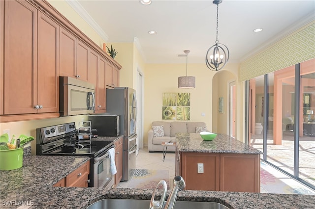 kitchen with appliances with stainless steel finishes, dark stone counters, sink, crown molding, and decorative light fixtures