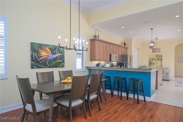 dining room featuring crown molding, a notable chandelier, and dark hardwood / wood-style flooring