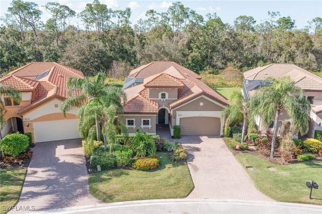 mediterranean / spanish-style home with a front lawn and a garage