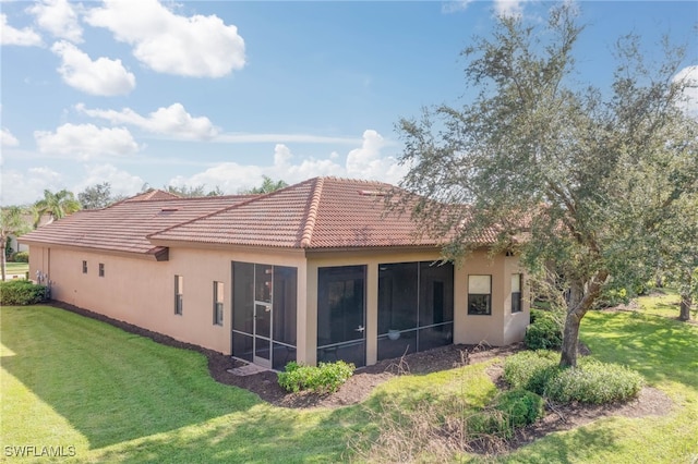 rear view of property featuring a yard and a sunroom