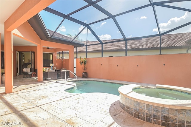 view of swimming pool with an in ground hot tub, a patio area, glass enclosure, and ceiling fan