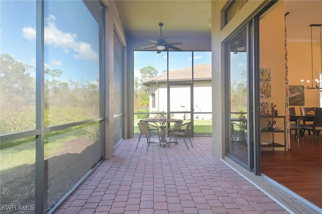 unfurnished sunroom with ceiling fan