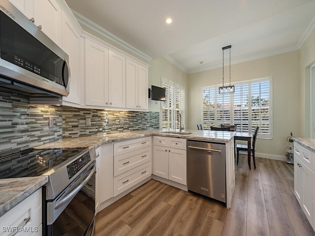 kitchen featuring hardwood / wood-style flooring, appliances with stainless steel finishes, tasteful backsplash, and white cabinets