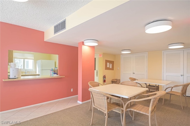 6900 Estero Blvd Unit 701, Fort Myers Beach, FL 33931 - dining area featuring visible vents, light tile patterned flooring, baseboards, light colored carpet, and a textured ceiling