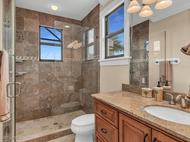 bathroom with vanity, an inviting chandelier, toilet, and a shower with shower door