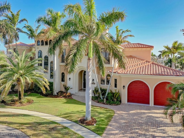 mediterranean / spanish house featuring a garage and a front yard