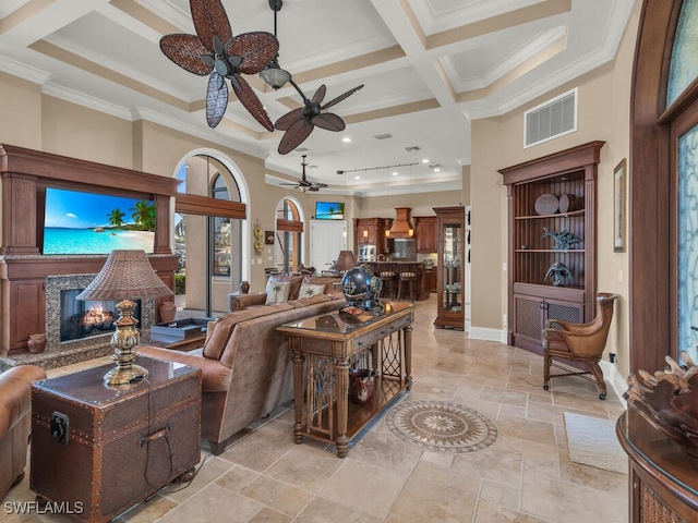 living room featuring beam ceiling, a high ceiling, coffered ceiling, a high end fireplace, and ornamental molding