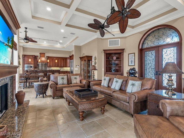 living room featuring crown molding, a towering ceiling, coffered ceiling, and ceiling fan