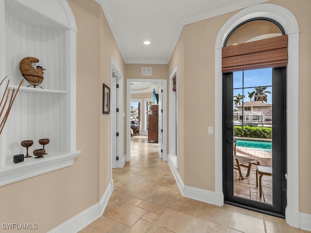 corridor with crown molding and plenty of natural light