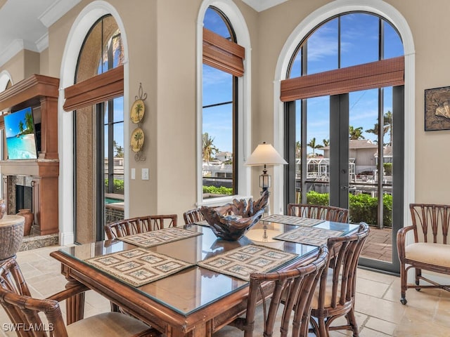 dining area with ornamental molding, a high ceiling, and a wealth of natural light