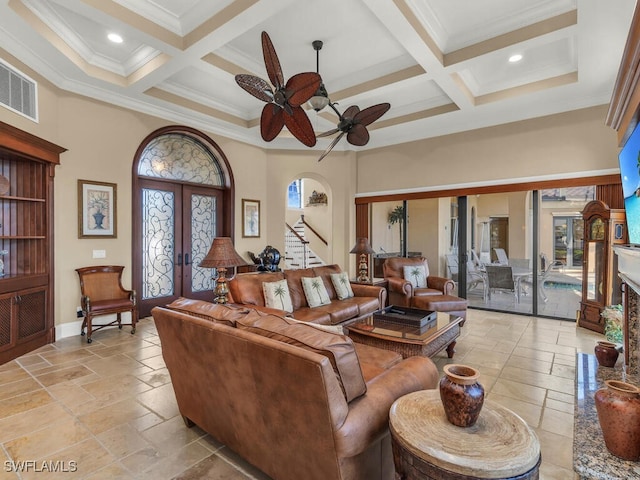 living room with beam ceiling, french doors, a high ceiling, coffered ceiling, and ornamental molding