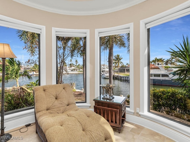 living area with a water view, a wealth of natural light, and ornamental molding