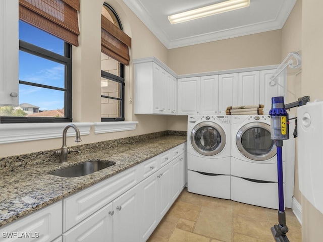 laundry area with cabinets, separate washer and dryer, crown molding, and sink