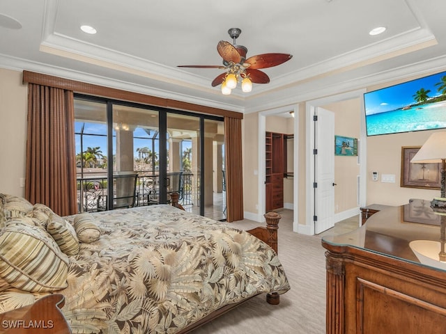 bedroom featuring access to exterior, ceiling fan, a tray ceiling, a walk in closet, and a closet