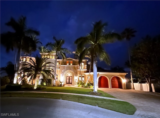 mediterranean / spanish-style house featuring a yard and a garage