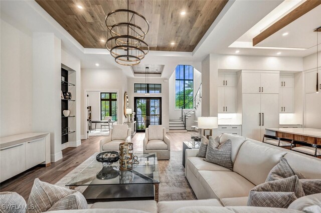 living room featuring french doors, dark hardwood / wood-style floors, a chandelier, a tray ceiling, and wood ceiling