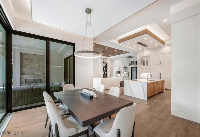 dining area featuring light wood-type flooring and sink