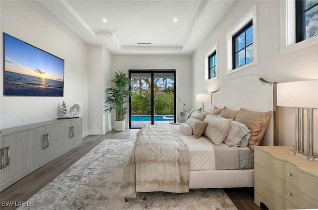 bedroom featuring a raised ceiling, access to exterior, and dark hardwood / wood-style flooring