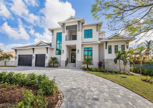 3540 Crayton Rd, Naples, FL 34103 - view of front of property with stucco siding, decorative driveway, a garage, and stone siding