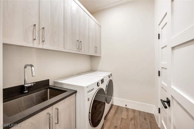 3540 Crayton Rd, Naples, FL 34103 - washroom with cabinet space, separate washer and dryer, light wood-style flooring, and baseboards
