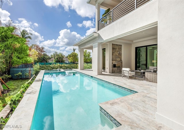 view of pool with an outdoor stone fireplace and a patio