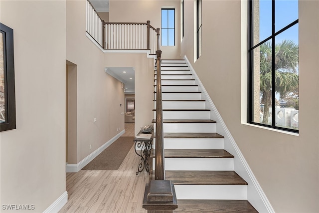 stairway with a high ceiling and hardwood / wood-style floors