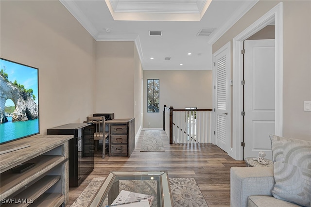 office space featuring light hardwood / wood-style floors, crown molding, and a tray ceiling